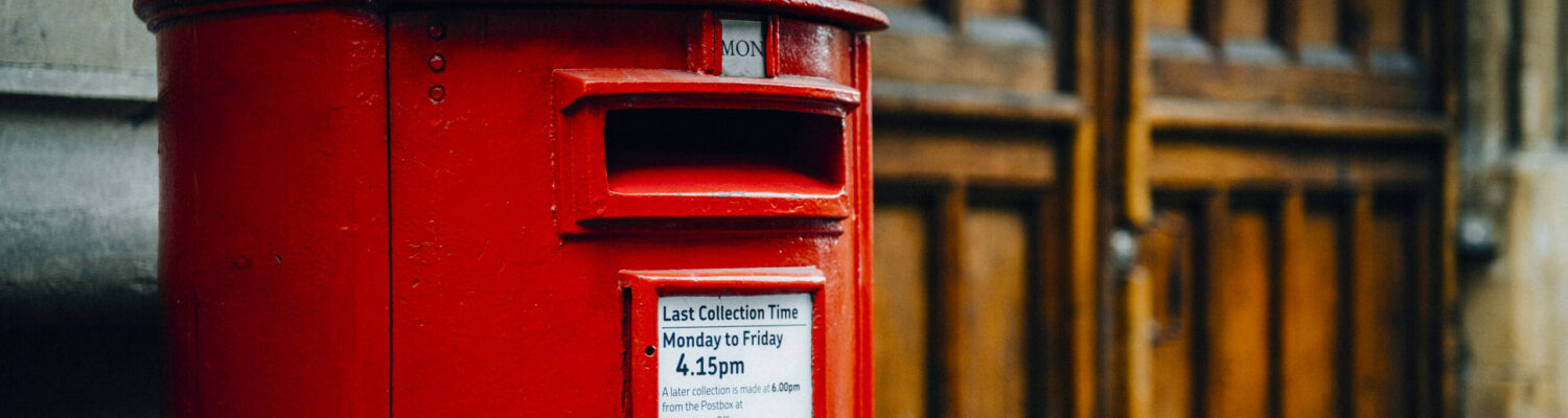 Iconic red British mailbox in a city