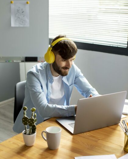 young-man-listening-to-music-on-headphones-while-working