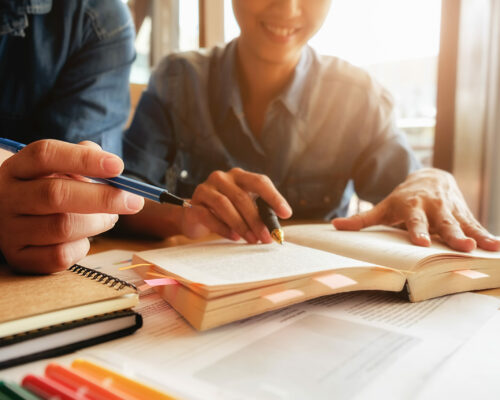 Education concept. Student studying and brainstorming campus concept. Close up of students discussing their subject on books or textbooks. Selective focus.