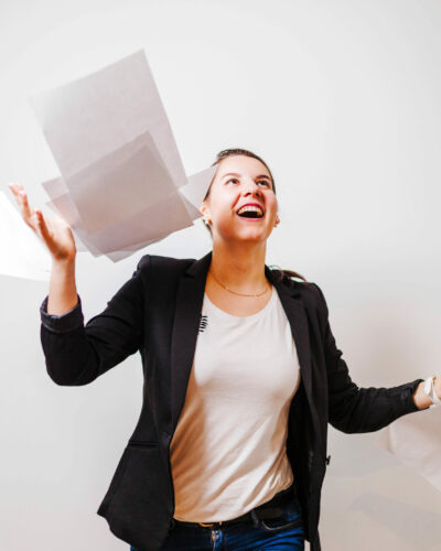 female-office-employee-throwing-up-papers